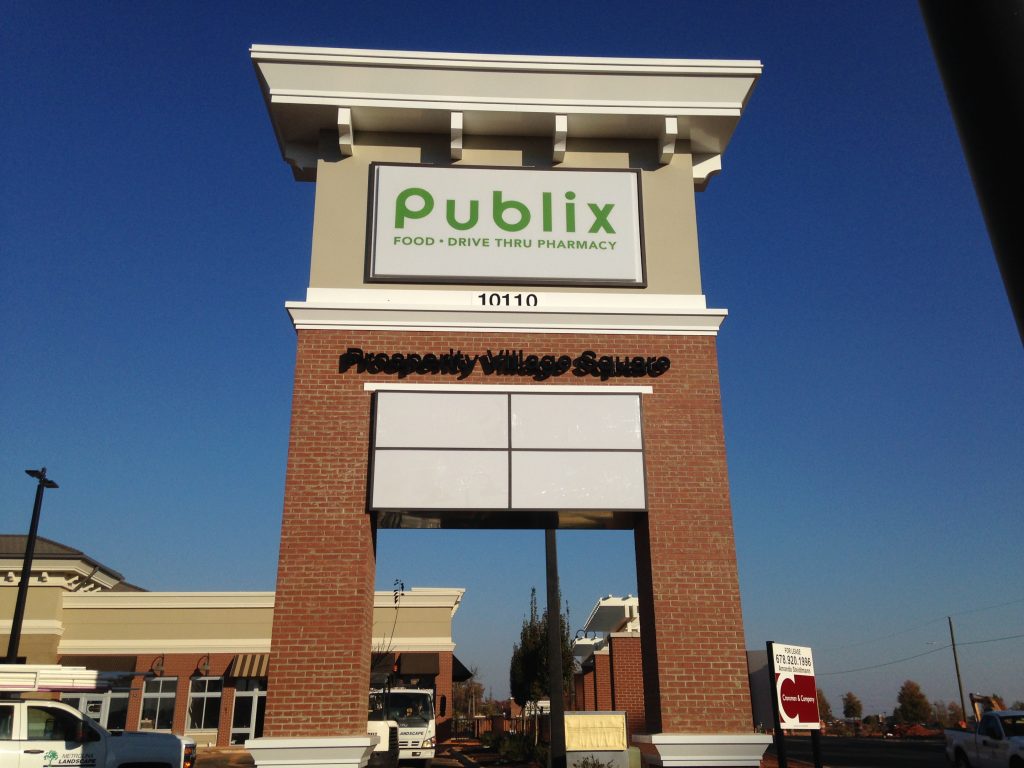 Multi-tenant pole sign supported by two brick columns.