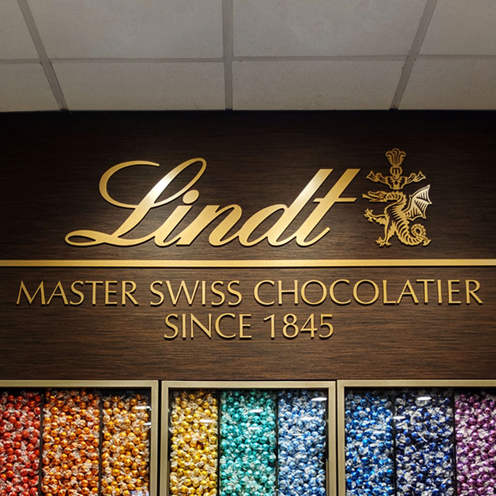 Lindt Chocolate sign on a wall above candy display