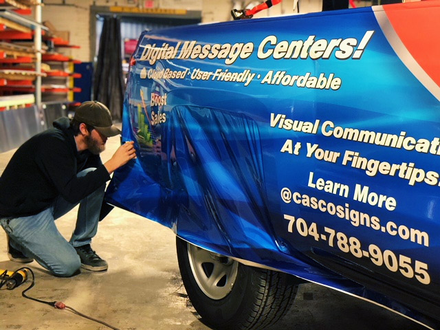Vinyl graphics being installed on the back of a truck.