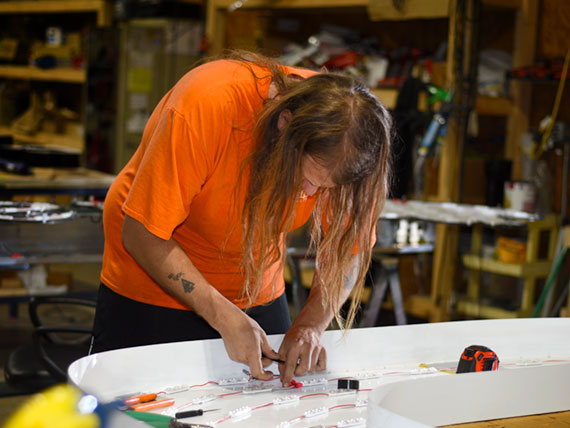 Assembly tech adding LED lights to a large channel letter.