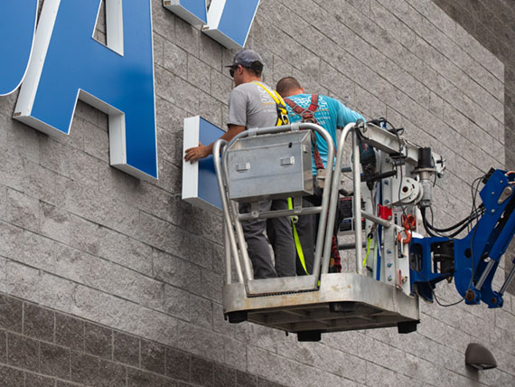 Sign installers placing channel letters