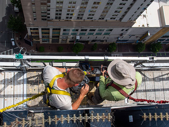 Installers on a swing stage working on a high rise building