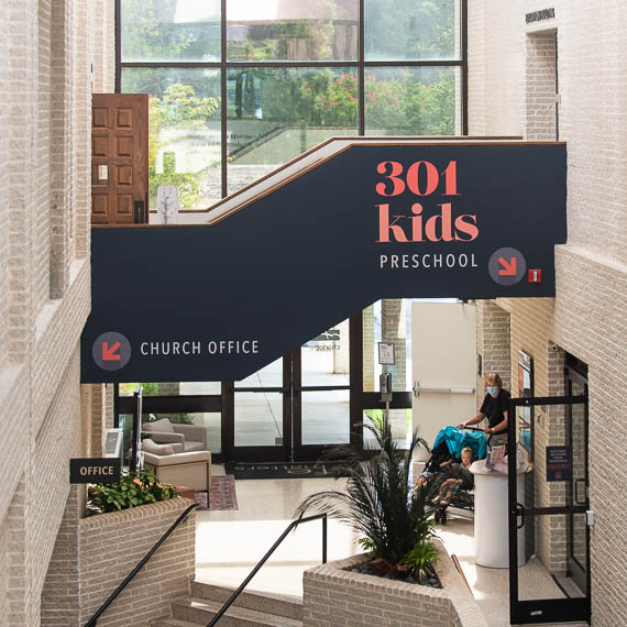Graphics on a walkway pointing to the church office and kids area.