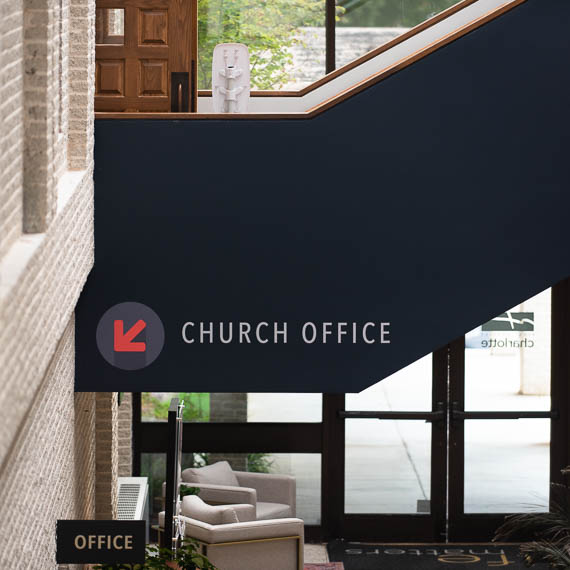 Directional signage pointing to the church office.