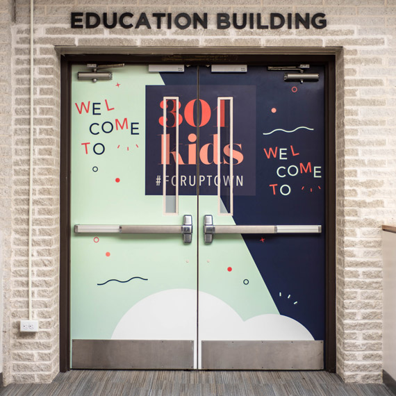 Environmental branding on double doors that lead to the children's area.