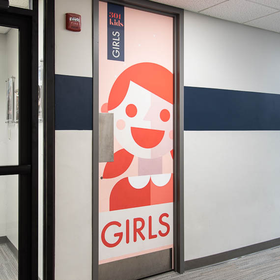 Playful artwork on a girl's restroom door.