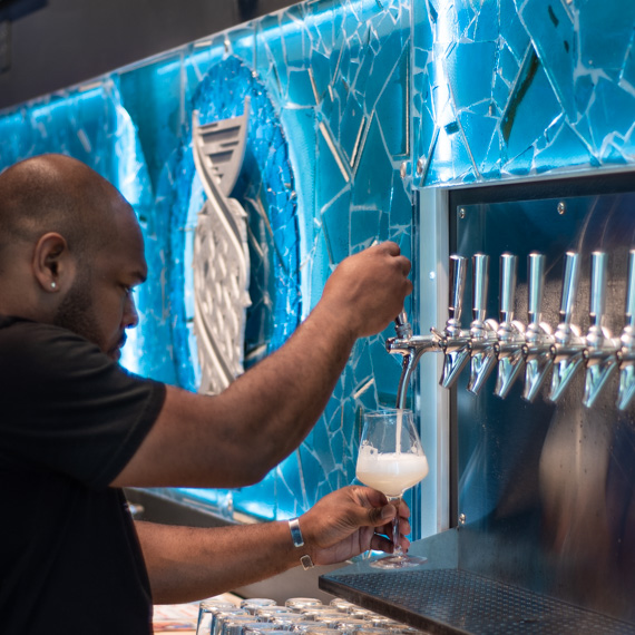 Creative sign integrated into artistic taproom backsplash.