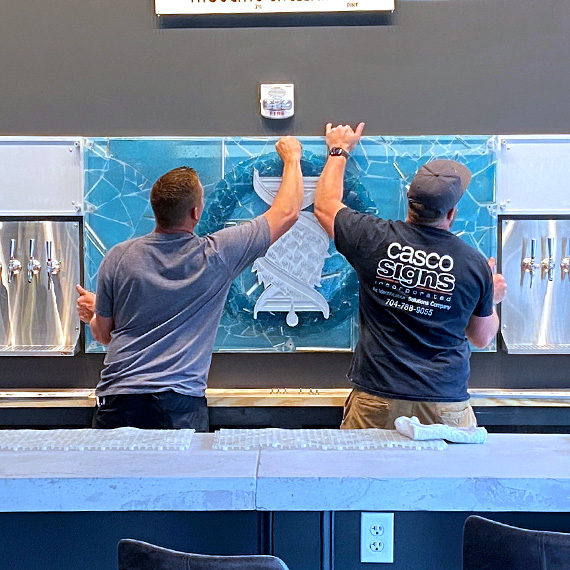 Casco Signs installing the glass mosaic backsplash at Southern Strain Brewing Company